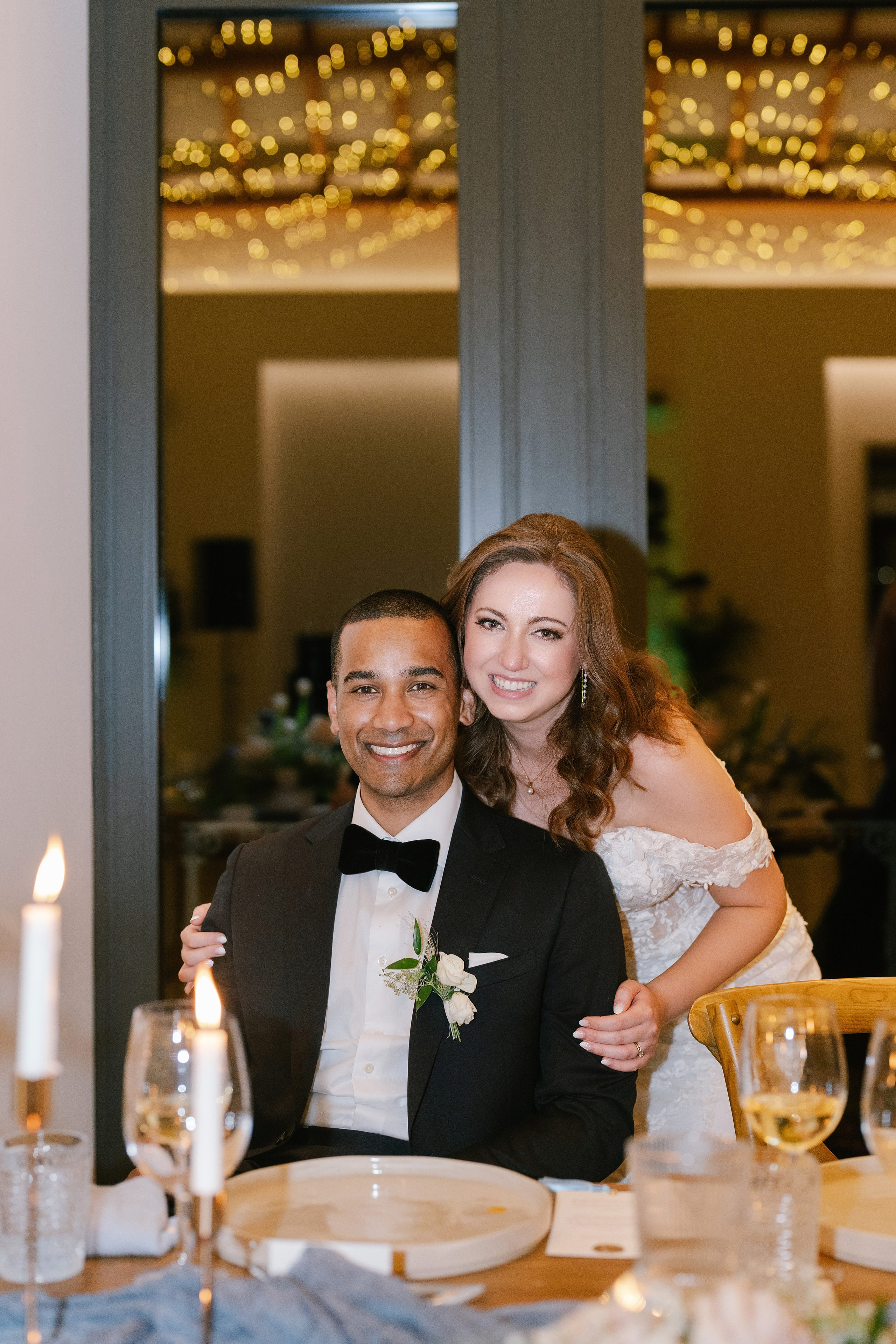 Bride and groom smiling at their reception table at Quinta do Gradil with fairy lights Bride and groom smiling at their reception table at Quinta do Gradil with fairy lights