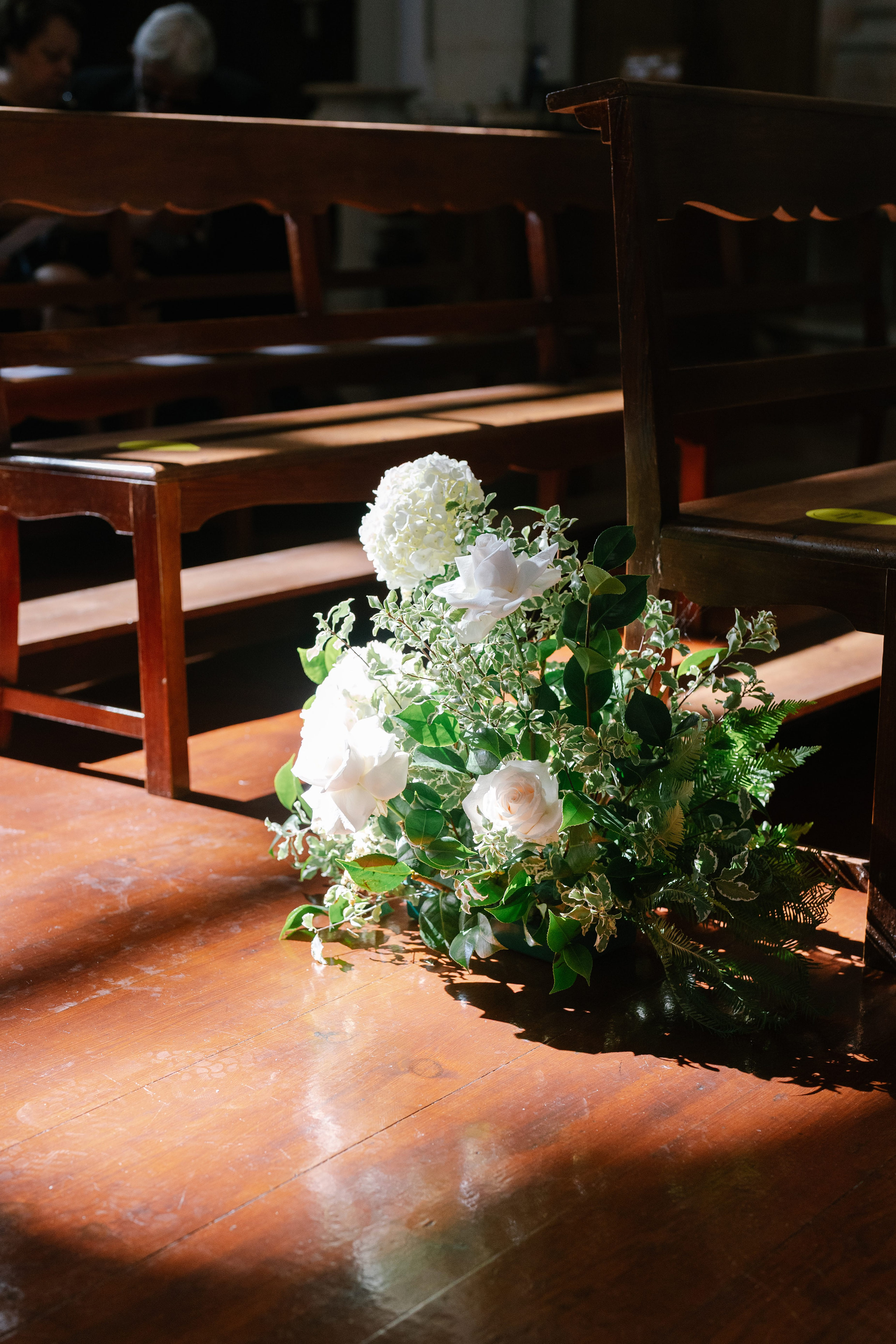 White rose and greenery floral arrangement illuminated by sunlight inside church in Portugal White rose and greenery floral arrangement illuminated by sunlight inside church in Portugal