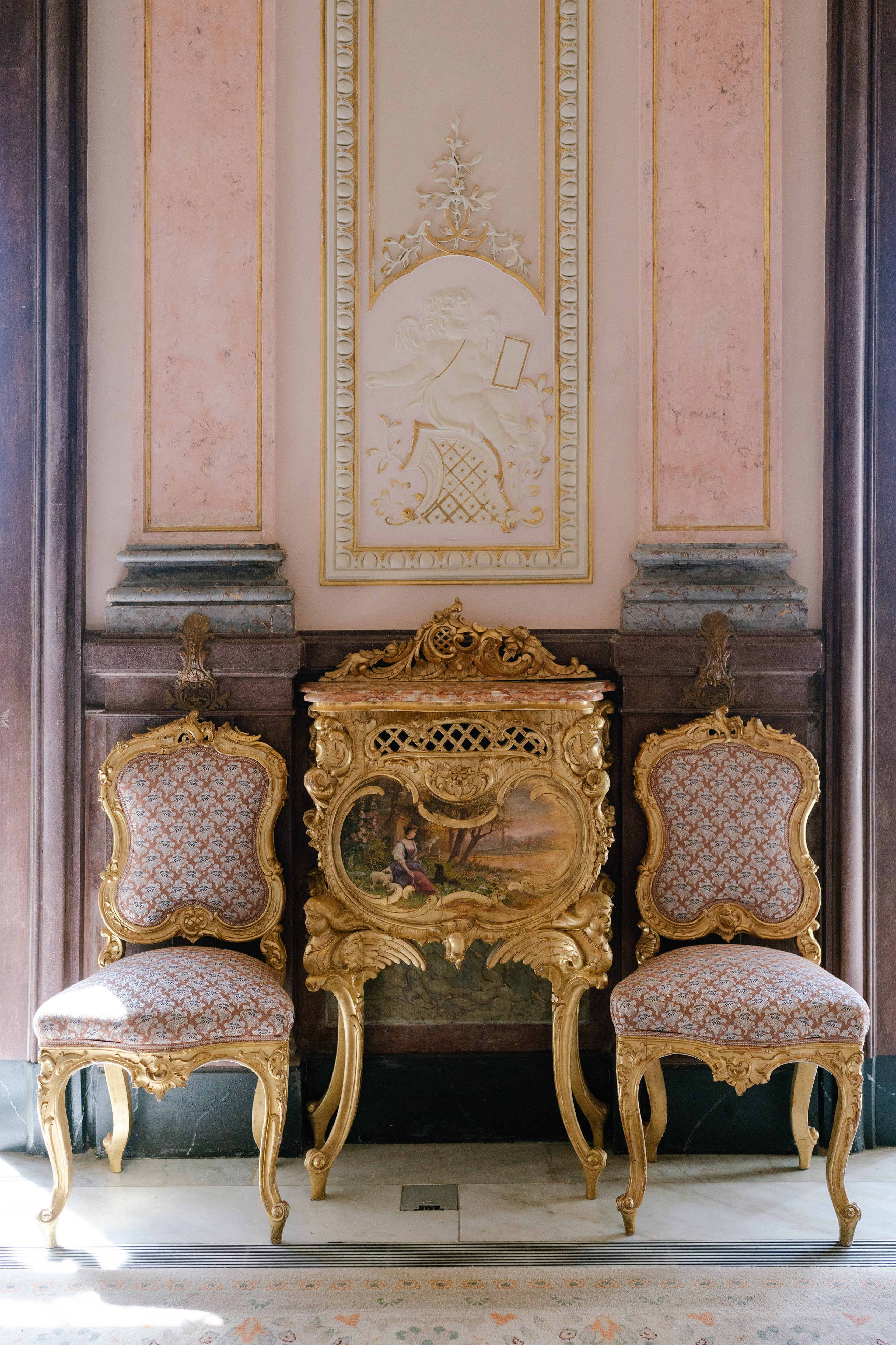 Gilded chairs and a painted cabinet in a pink salon of the Palácio de Estoi, Algarve Gilded chairs and a painted cabinet in a pink salon of the Palácio de Estoi, Algarve
