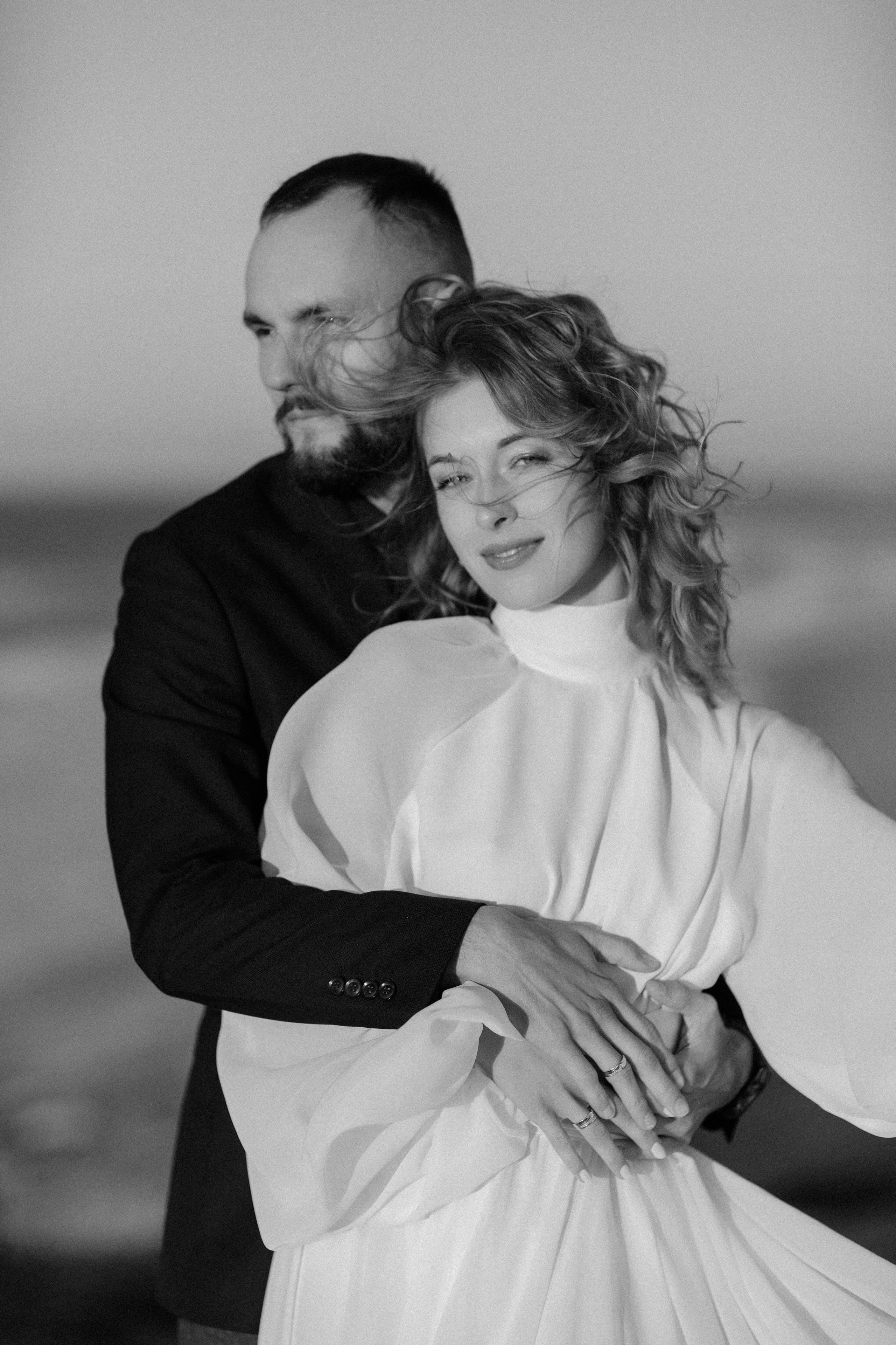 Couple embracing at Praia del Rey, in black and white