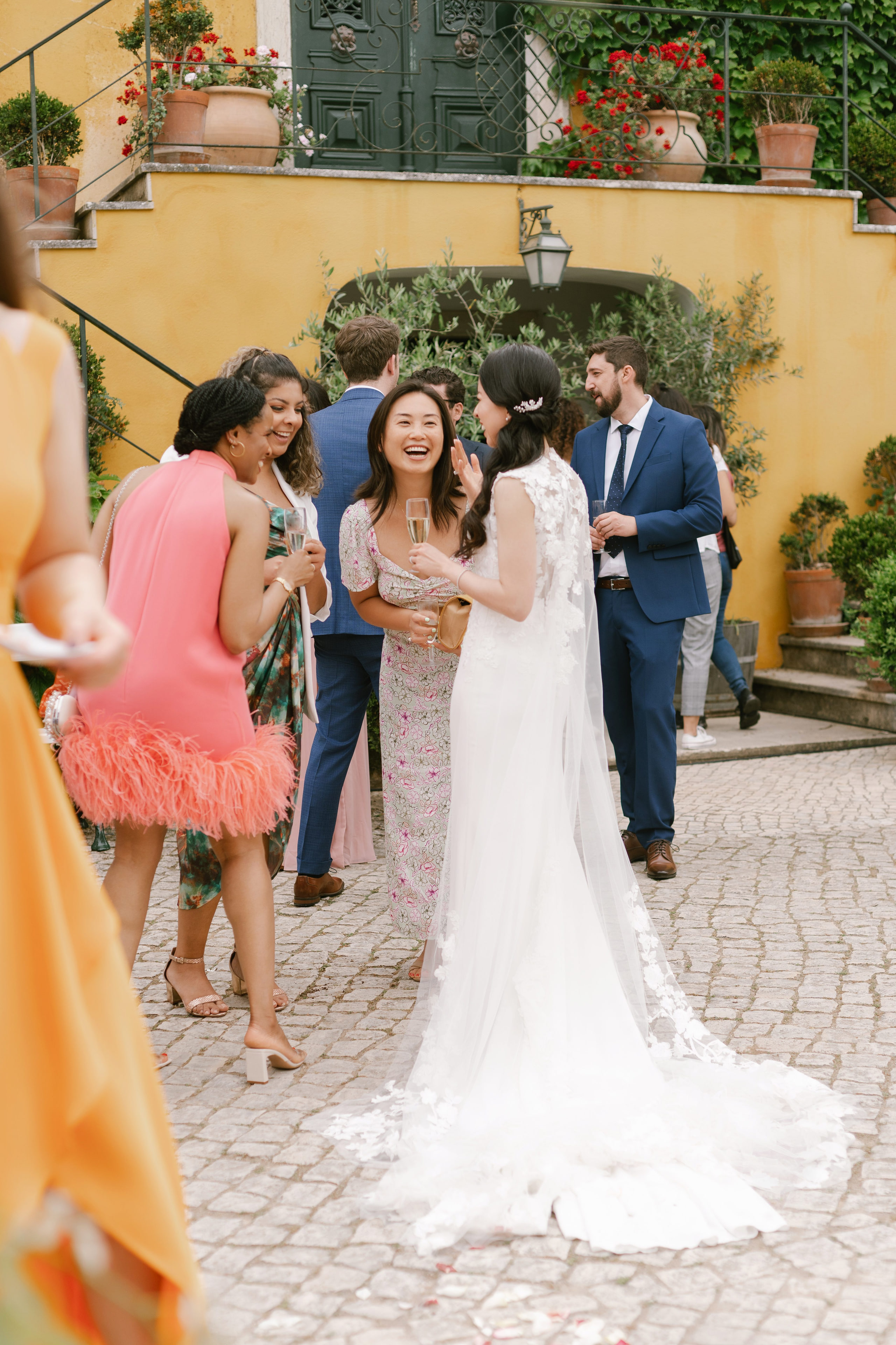 Wedding guests with sparkling wine laughing with the bride at Quinta de Sant'Ana, Portugal Wedding guests with sparkling wine laughing with the bride at Quinta de Sant'Ana, Portugal